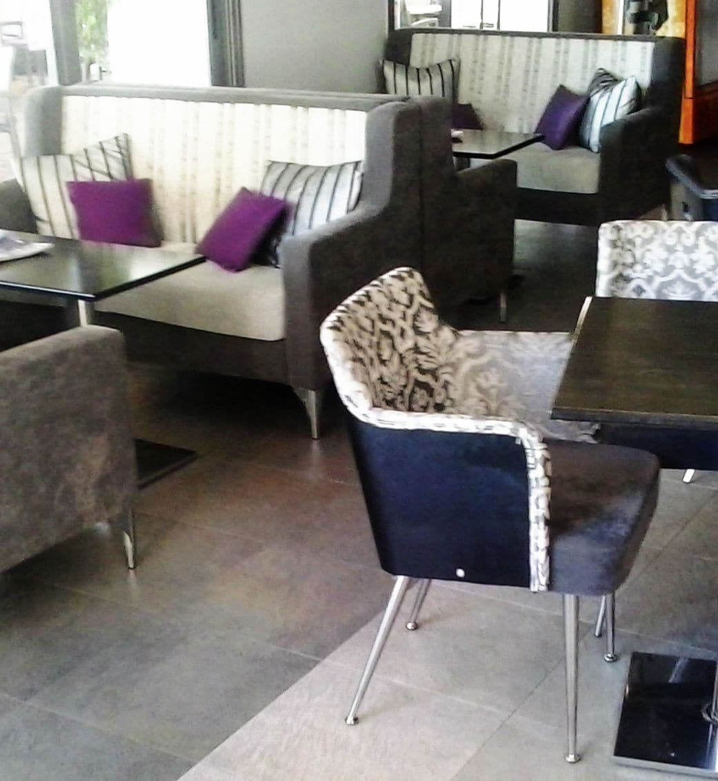 Un área de descanso moderna con un sofá, sillones y una mesa de centro.