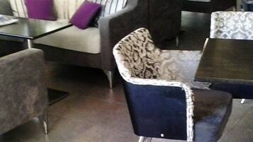 Un área de descanso moderna con un sofá, sillones y una mesa de centro.