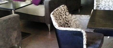 Un área de descanso moderna con un sofá, sillones y una mesa de centro.