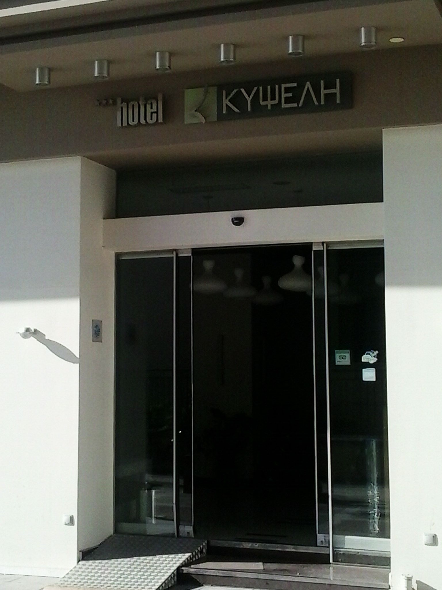 A hotel entrance with a glass door and a ramp leading up to it.