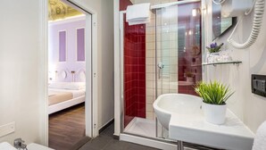 A modern bathroom with a glass-enclosed shower, a white sink, and a small potted plant. - Hotel Ferrucci Firenze (Florence)