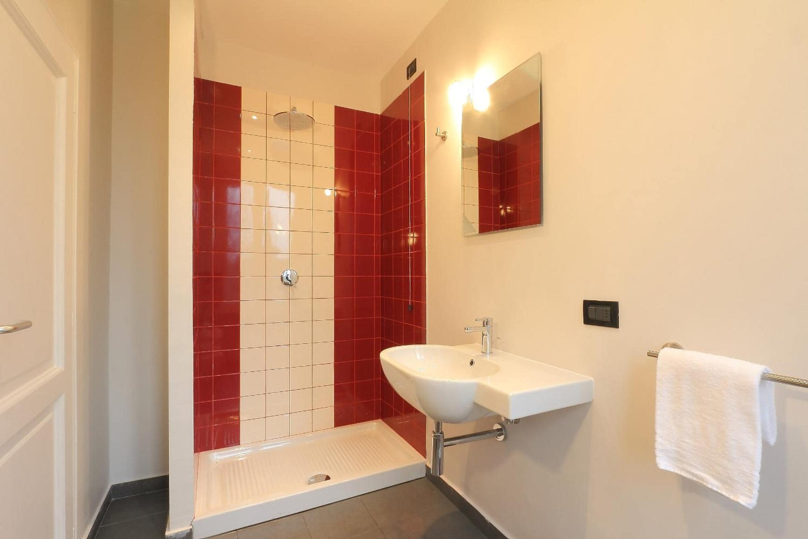 A bathroom with a shower, sink, and mirror.