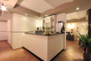 A modern kitchen with a central island, white cabinetry, and a built-in wine rack. - Hotel Ferrucci Firenze (Florence)