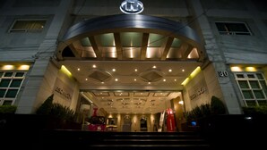A hotel entrance with a curved canopy, multiple lights, and a prominent logo above the doors. - KALI Escandon Mexico City (Mexico City)