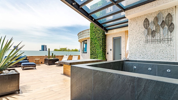 A rooftop terrace with a glass ceiling, a seating area with a pool, and a wall with a green vertical garden. - KALI Escandon Mexico City (Mexico City)