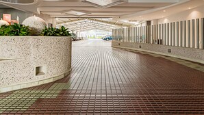 A spacious lobby with a tiled floor, a reception area with a large planter, and a modern ceiling design. - KALI Escandon Mexico City (Mexico City)