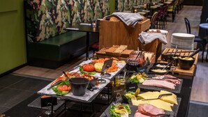A buffet setup with various food items and utensils. - Thon Hotel Tromsø (Tromsø)