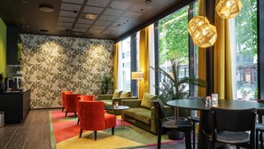 A modern interior with a patterned wall, seating area, and large windows. - Thon Hotel Tromsø (Tromsø)