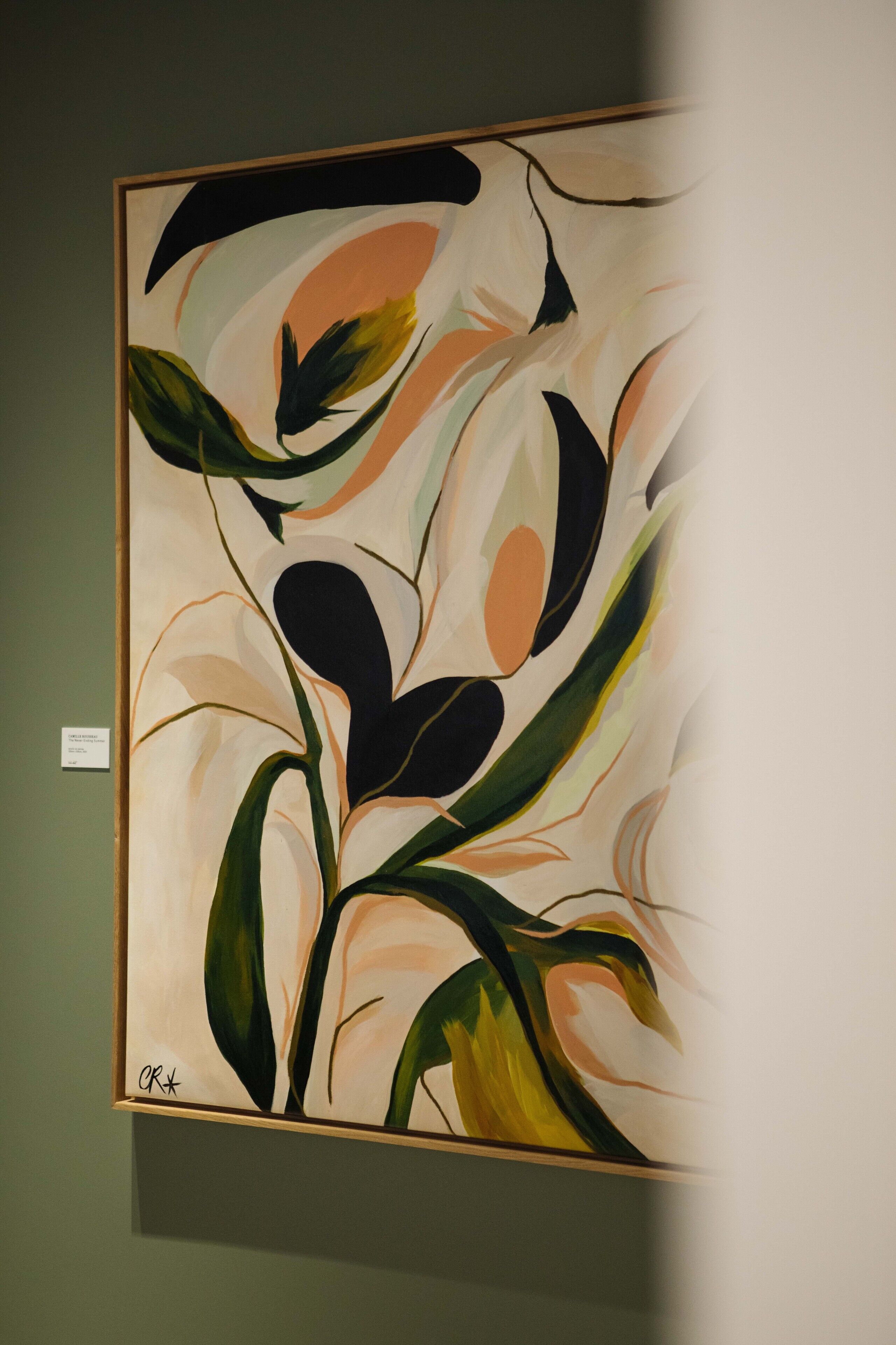 A framed abstract painting with a signature on the bottom left.