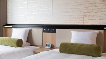 Una habitación de hotel con dos camas, un cabecero de madera, un reloj digital y una mesita de noche.