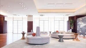 A spacious lobby with a modern design, featuring a large seating area with a sofa and armchairs, a coffee table, and a potted plant. - Hotel MyStays Kyoto - Shijo (Kyoto)