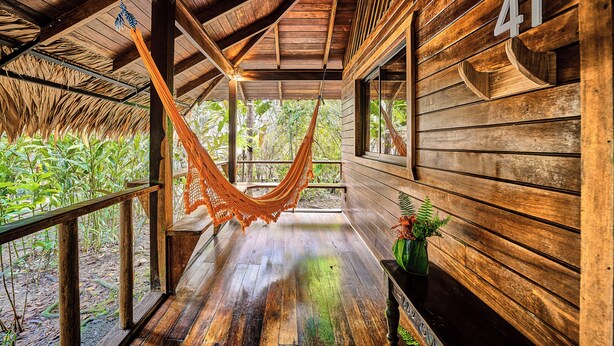 A wooden cabin with a hammock, wooden walls, and a number '41' sign. - Cariblue Beach and Jungle Resort (Cahuita)