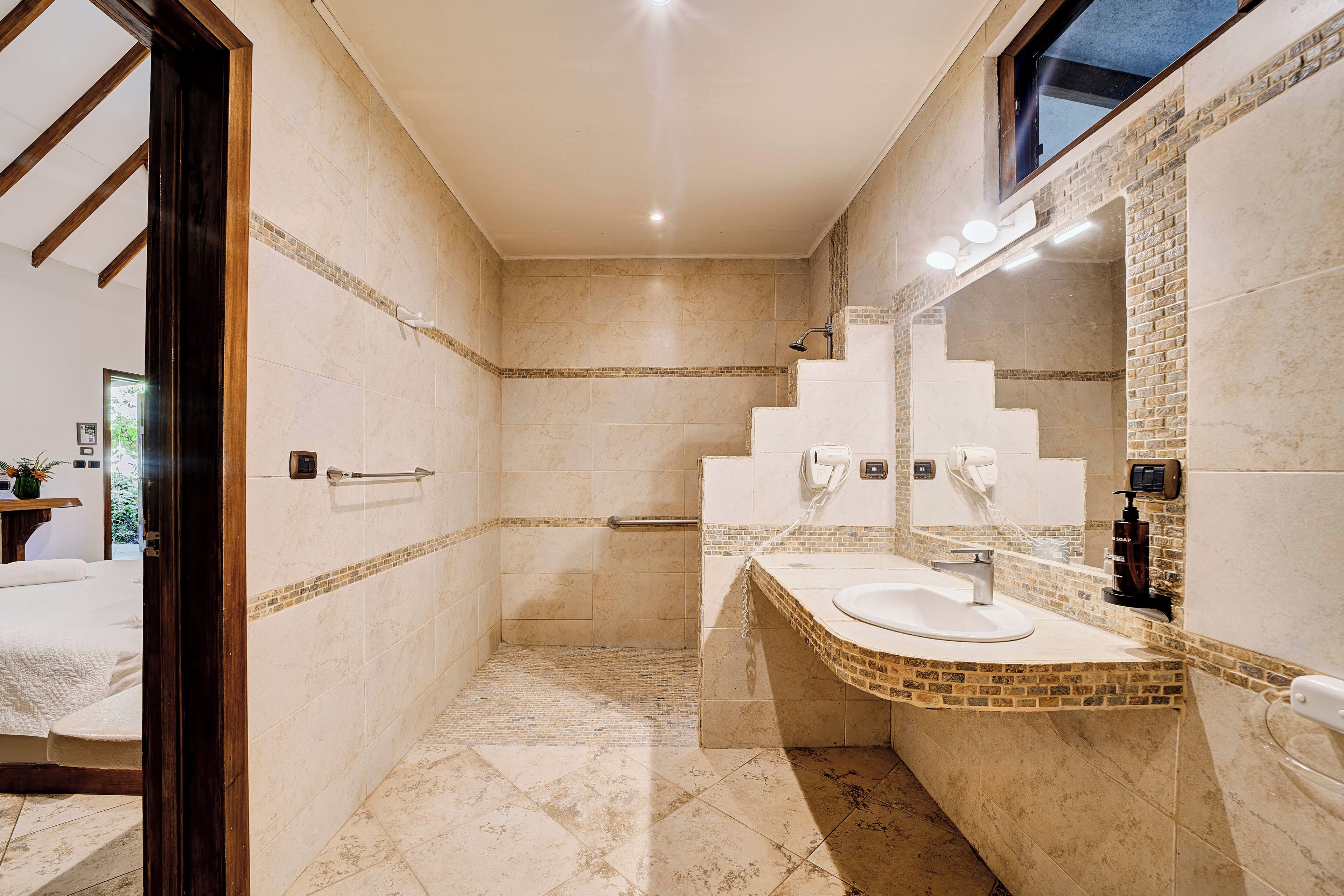 A bathroom with a shower, a sink, and a mirror.