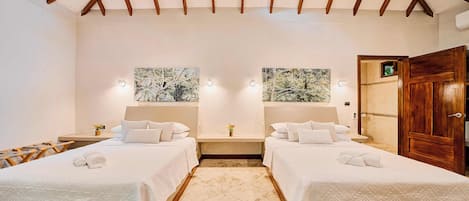 Une chambre d’hôtel avec deux lits, un plafond en bois et des œuvres d’art accrochées aux murs.
