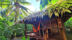 A wooden structure with a thatched roof, surrounded by lush greenery and a wooden staircase leading up to it. - Cariblue Beach and Jungle Resort (Cahuita)