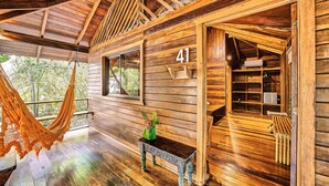 A wooden cabin interior with a hammock, a bench, and a number '41' on the wall. - Cariblue Beach and Jungle Resort (Cahuita)