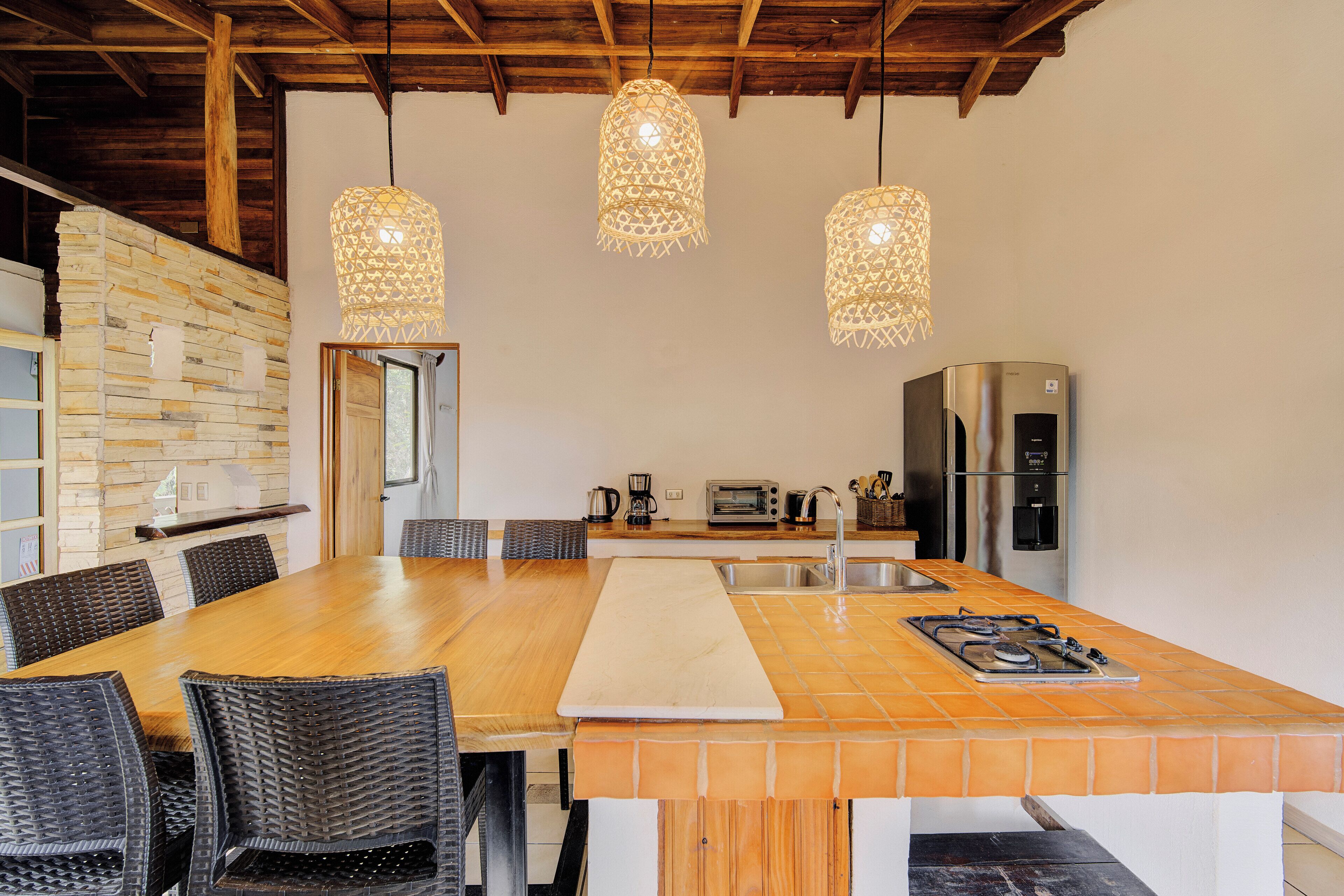 A spacious kitchen with a large island, modern appliances, and hanging pendant lights.