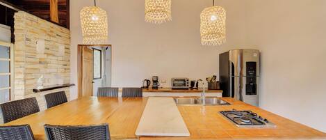 A spacious kitchen with a large island, modern appliances, and hanging pendant lights.