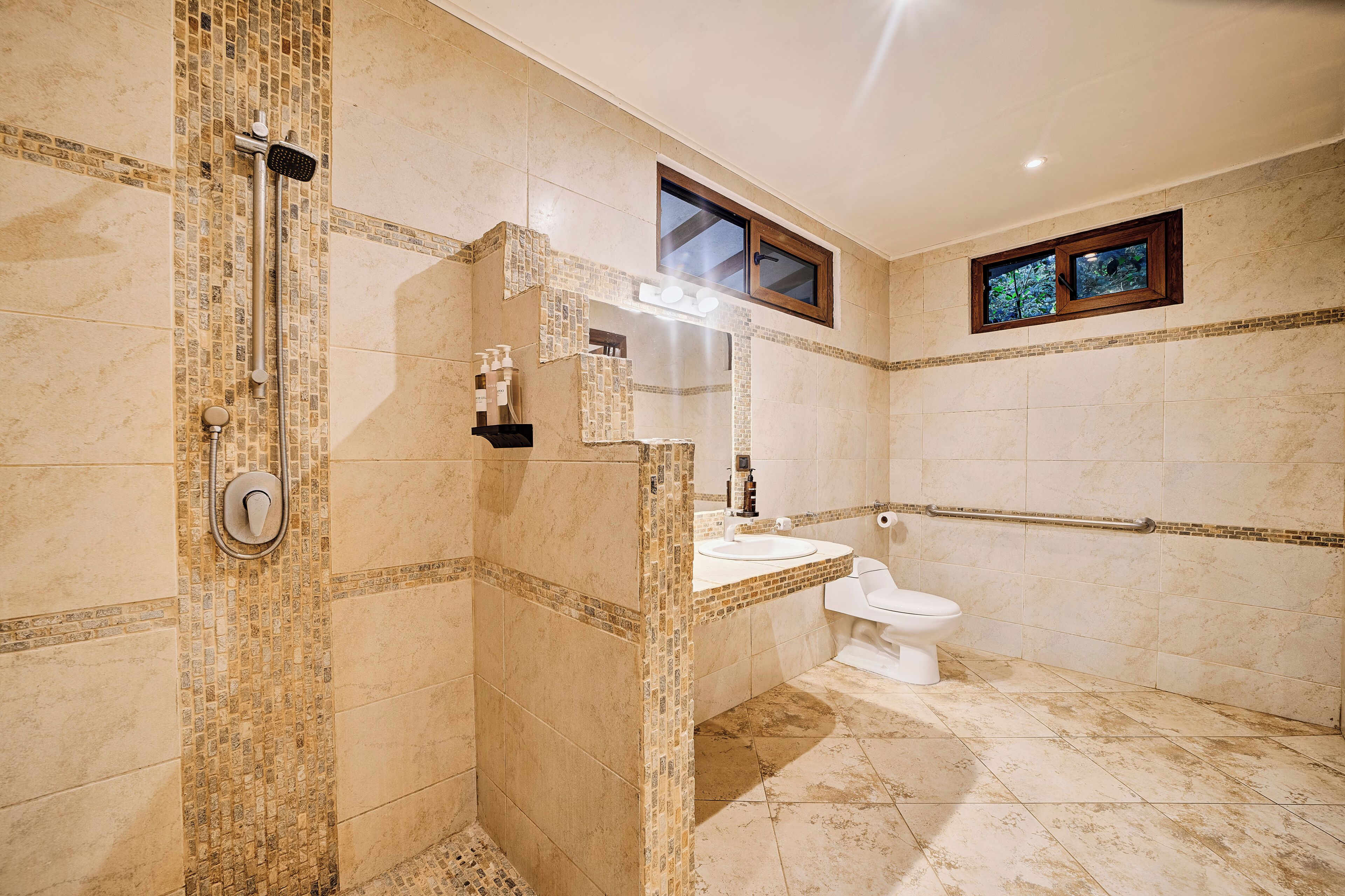 A bathroom with a shower, toilet, and sink.