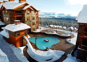 A resort with a pool, wooden cabins, and a snowy landscape. - Sundance Resort (Beaverdell)