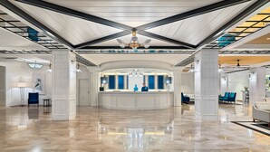 A spacious lobby with a high ceiling, a reception desk, and a chandelier. - H10 Delfín - Adults Only (Salou)