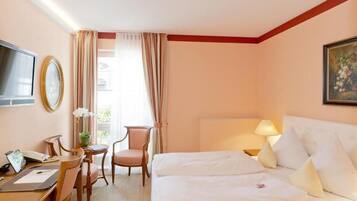 Une chambre d’hôtel équipée d’un lit, d’un bureau, d’une chaise et d’un téléviseur.
