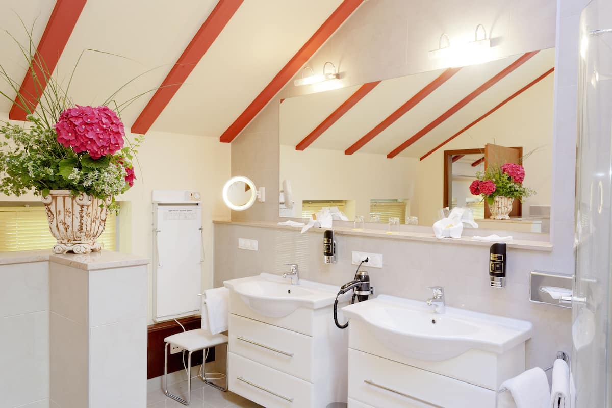 A modern bathroom with two sinks, a mirror, and a vanity.
