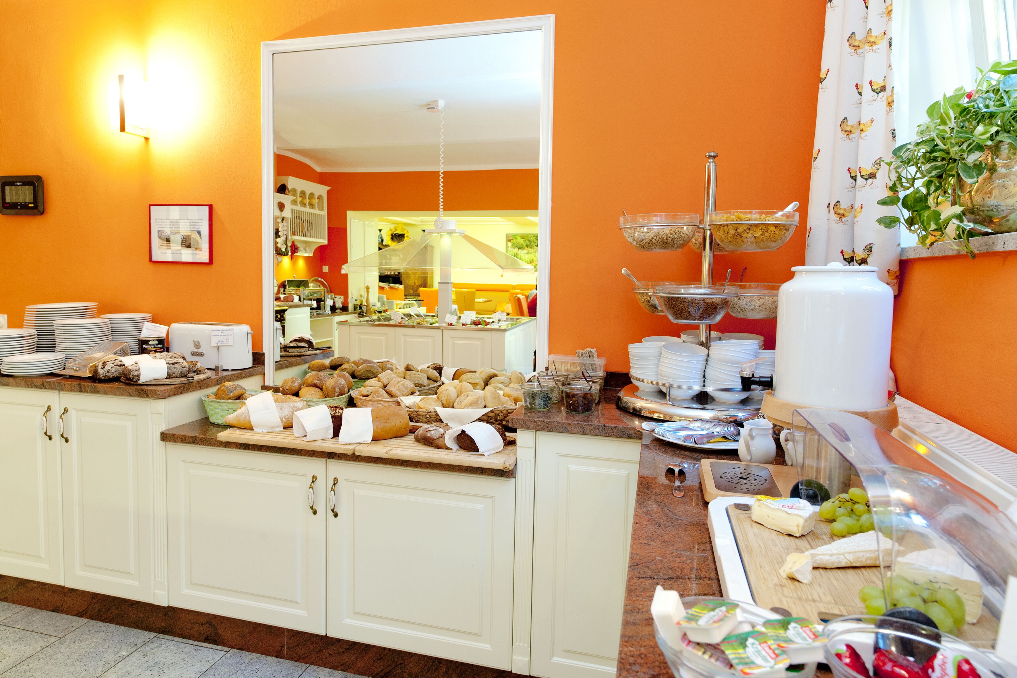 Un buffet con diversi cibi e una cucina sullo sfondo.