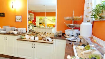 Un buffet con diversi cibi e una cucina sullo sfondo.