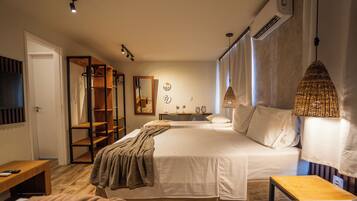 Quarto com cama, mesas de cabeceira, guarda-roupa e espelho.