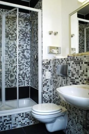 Ein Badezimmer mit Dusche, Toilette und Waschbecken.