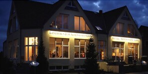 Ein Gebäude mit einem Schild, auf dem "Landhaus Zur Alten Gärtnern" steht, und einem weiteren Schild für "Hotel, Restaurant, Café".