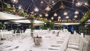 A banquet hall with long tables set for a formal event, featuring white tablecloths, silverware, and crystal glasses. - Villa Giuliana Relais (Licata)