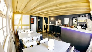 A restaurant with a wooden ceiling, white tables, and chairs. There is a counter with a neon sign and various items on display. - Hotel Elch (Nuremberg)