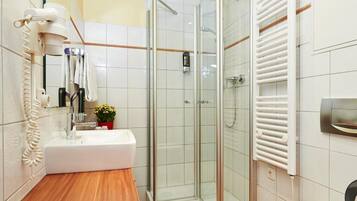 A modern bathroom with a wooden vanity, a glass shower enclosure, and a white toilet.