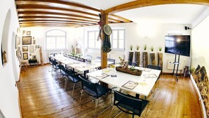 A spacious dining area with high wooden beams, long tables, and chairs. - Hotel Elch (Nuremberg)