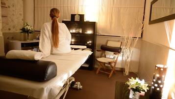 Relax in comfort with a large bed, massage table, and cozy seating area.