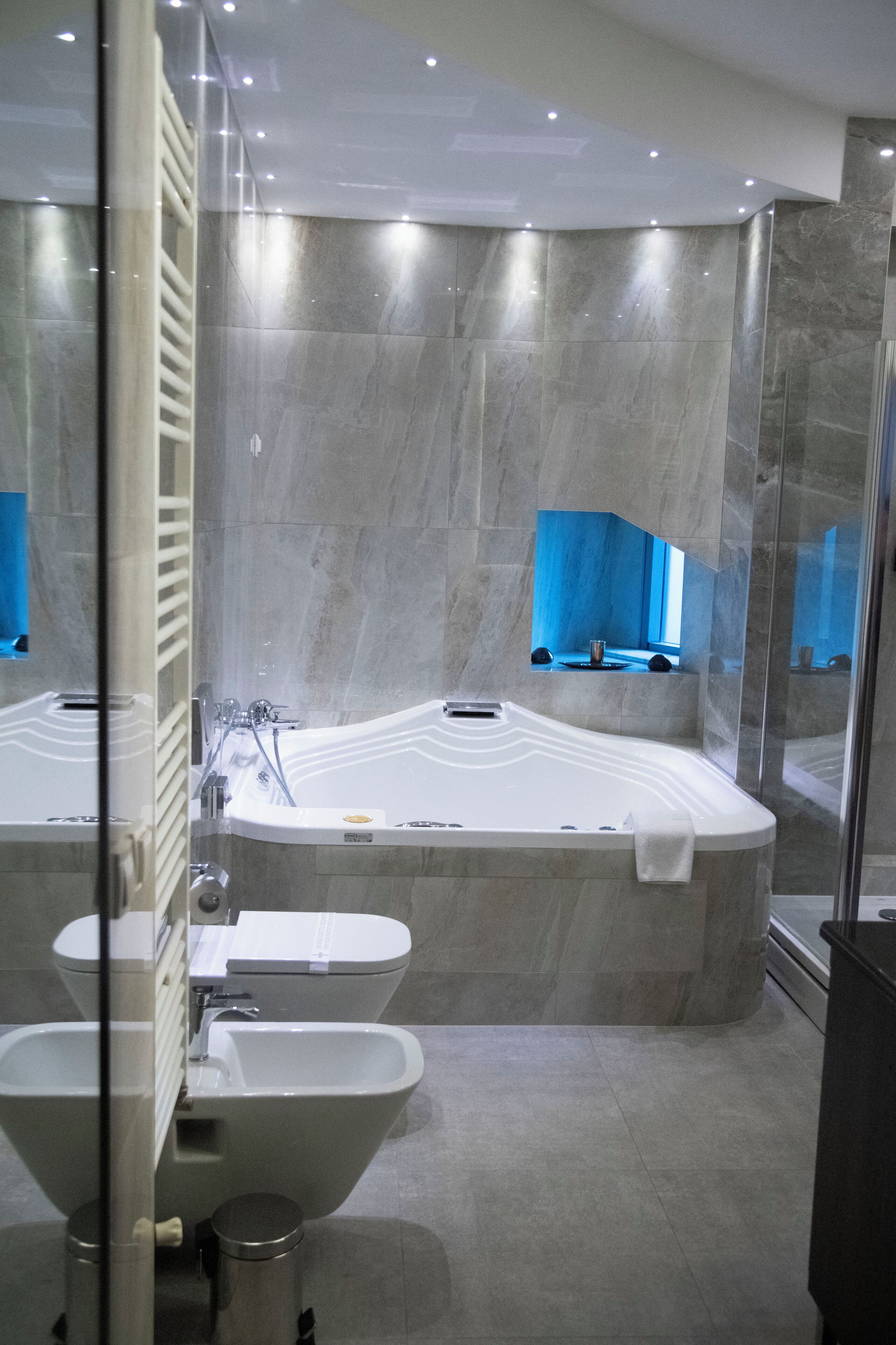 A modern bathroom with a large bathtub, a separate sink, and a glass-enclosed shower area.