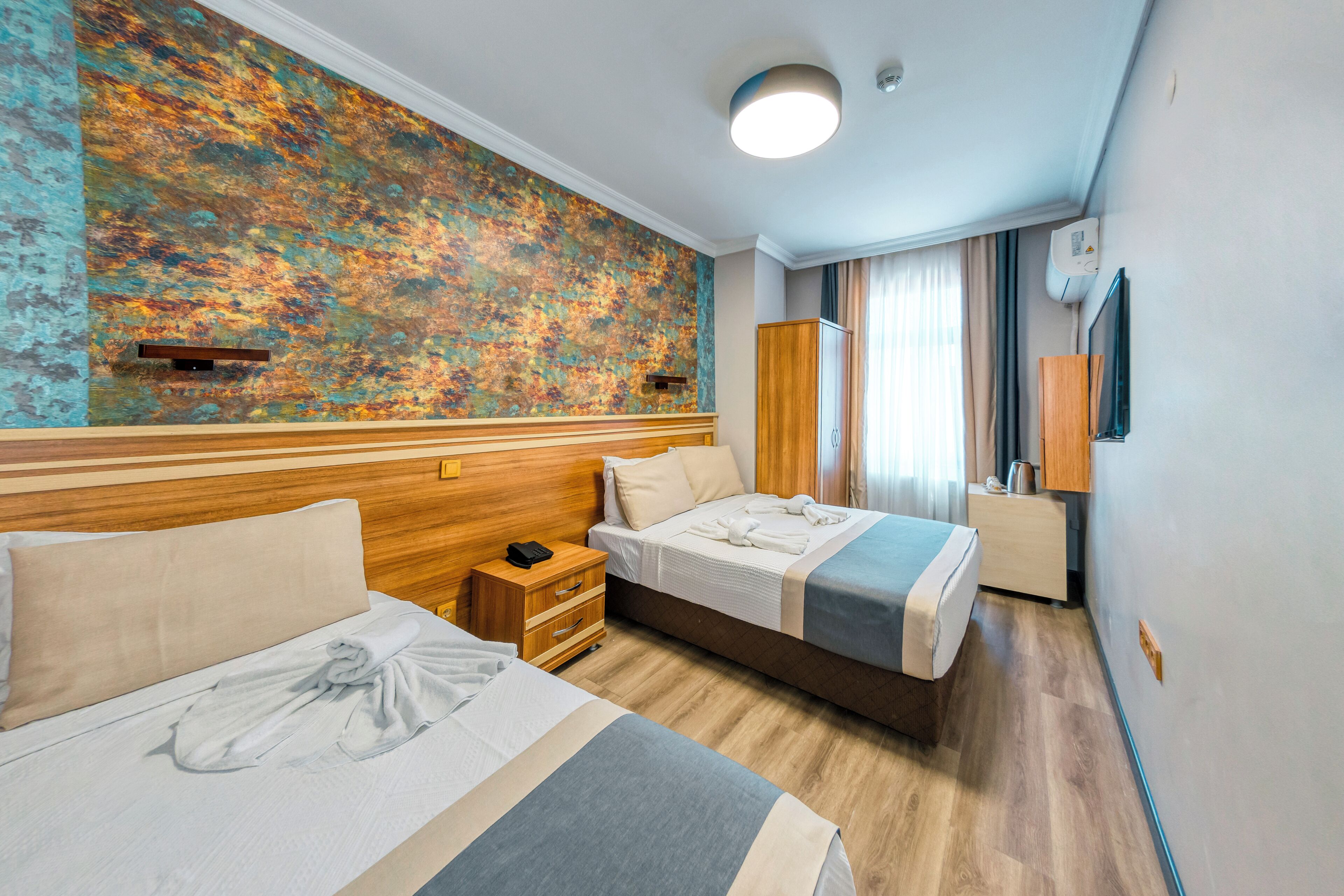 Triple Room | Minibar, in-room safe, individually decorated, individually furnished