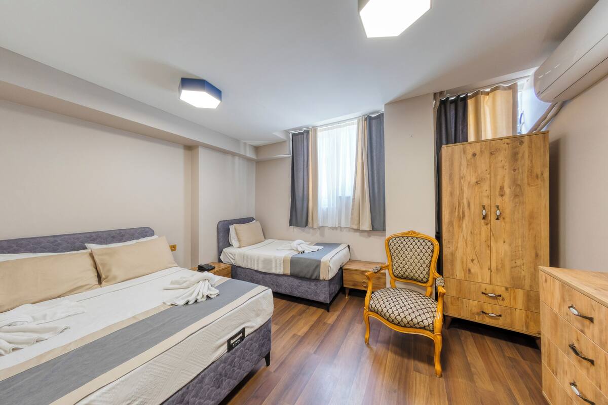 A bedroom with a bed, a chair, a wardrobe, and a nightstand.