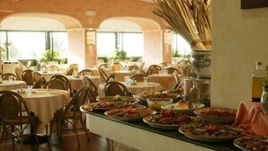 A restaurant with multiple round tables, each set with chairs, plates of food, and a variety of dishes. - LABRANDA Rocca Nettuno Tropea (Tropea)