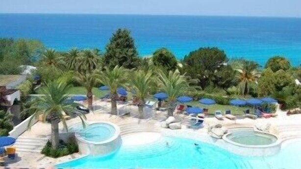 A resort pool area with palm trees, lounge chairs, and umbrellas. - LABRANDA Rocca Nettuno Tropea (Tropea)