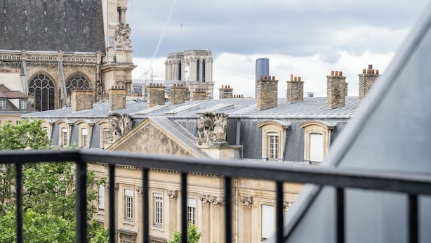 A historic building with ornate architecture, including a statue and a tower. - Hotel De Nice (Paris)