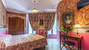 A room with a bed, a desk with a chair, a lamp, a painting on the wall, and curtains. - Hotel De Nice (Paris)