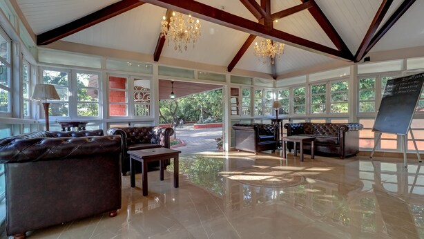 A spacious lobby with a high ceiling, chandeliers, and large windows offering a view of the outdoors. - Citrus Chambers Mahabaleshwar (Mahabaleshwar)
