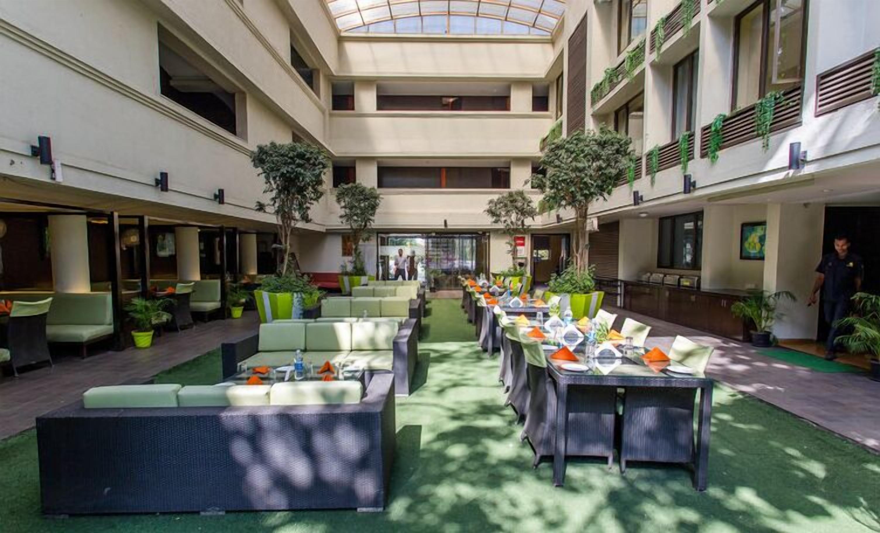 A spacious atrium with high ceilings, multiple seating areas, and indoor plants.