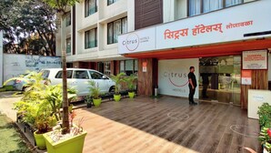 A hotel named 'Citrus Hotels' with a modern design, featuring a wooden floor and potted plants. - Citrus Hotel Lonavala (Mawal)