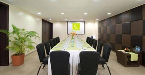 Conference room with a long table, chairs, and amenities for meetings and events.