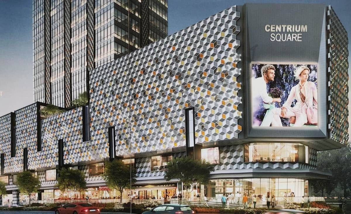 A modern building with a geometric facade and a large advertisement for Centrium Square.