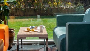 A modern outdoor seating area with a table, chairs, and a view of a garden. - ibis Gaziantep (Gaziantep)